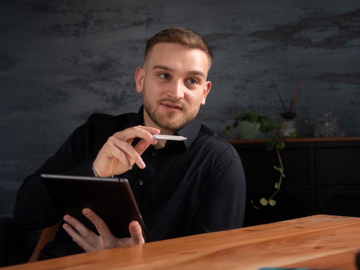 Kevin Butusow im Gespräch, mit Tablet am Besprechungstisch